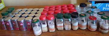 Rows of layered soup jars and coffee tins laid out on a table, ready to be handed out.