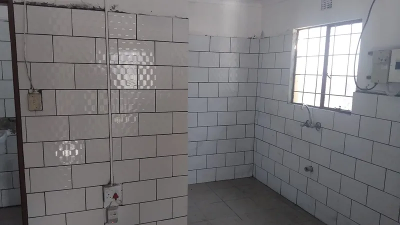 Two more views of the tiled kitchen walls, with a tap fitted below the window and the electrical fittings in place.
